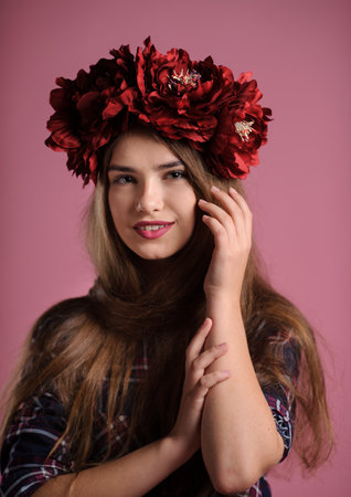 portrait of a beatiful girl with a wine-colored wreath in studio over pink backgroundの写真素材
