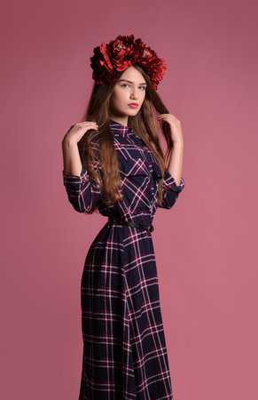 beatiful girl with a wine-colored wreath in studio over pink backgroundの写真素材