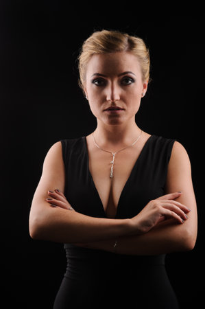 fashion picture of beautiful young blonde woman wearing black dress nice makeup. Studio picture, black backgroundの写真素材