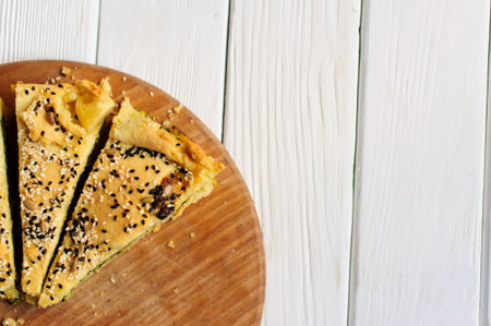 Homemade spinach french pie quiche lorraine on a white wooden boardの写真素材