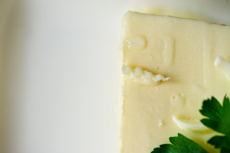 piece of butter with parsley on a deskの写真素材
