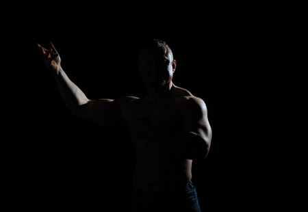 Image of muscle man posing in studio over black backgroundの写真素材