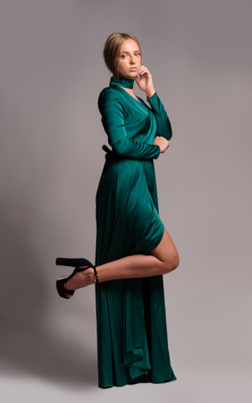 Pretty girl in green dress. Studio picture, grey backgroundの写真素材