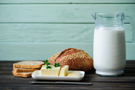 traditional bread loaf with jug of milk on a wooden boardの写真素材