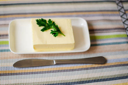 piece of butter with knife on a wooden deskの写真素材