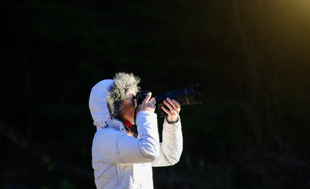 photographer with camera outdoor making landscape pictureの写真素材