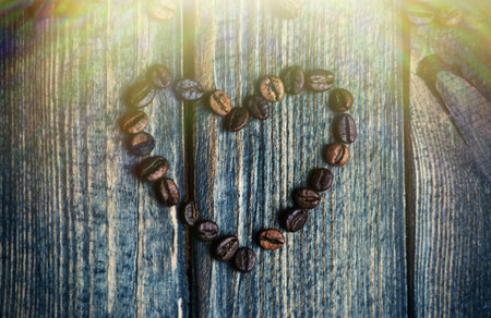 heart made from coffee beans on wooden background