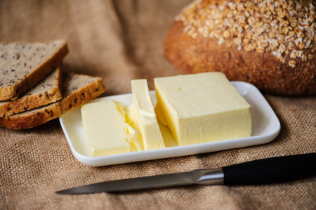 piece of butter with bread on a sacking textile materialの写真素材
