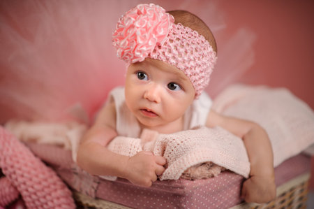 Newborn baby in a basket on pink backgroundの写真素材