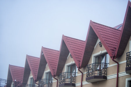 red metal tiles roof over the cloud foggy skyの写真素材