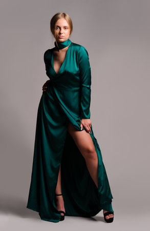 Pretty girl in green dress. Studio picture, grey backgroundの写真素材