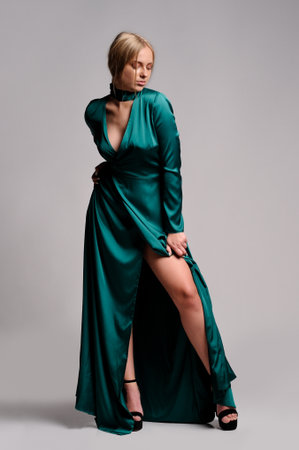 Pretty girl in green dress. Studio picture, grey backgroundの写真素材