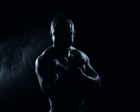 Image of muscle man posing in studio over black backgroundの写真素材