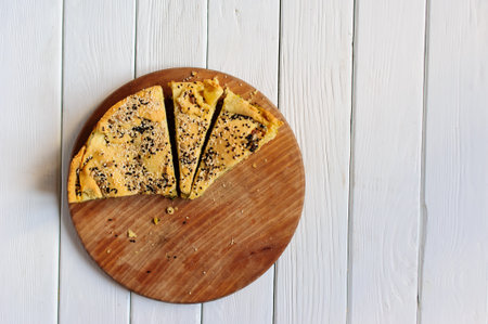 Homemade spinach french pie quiche lorraine on a white wooden board