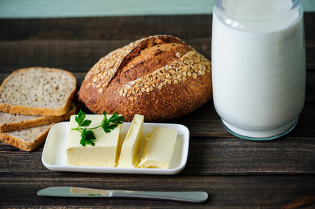 traditional bread loaf with jug of milk on a wooden boardの写真素材