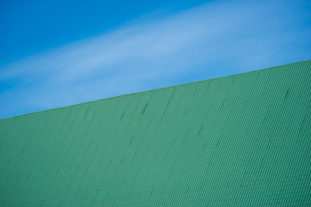 green metal tiles roof over the blue skyの写真素材