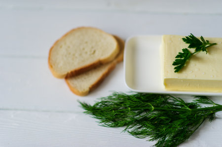 piece of butter with parsley on a white wooden deskの写真素材