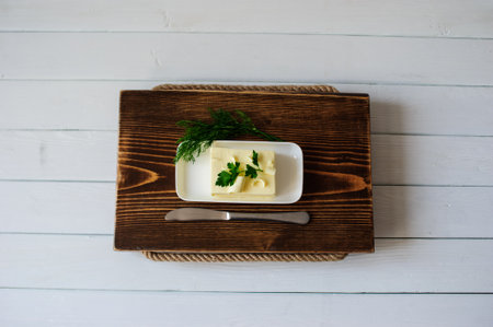 piece of butter with knife on a wooden deskの写真素材
