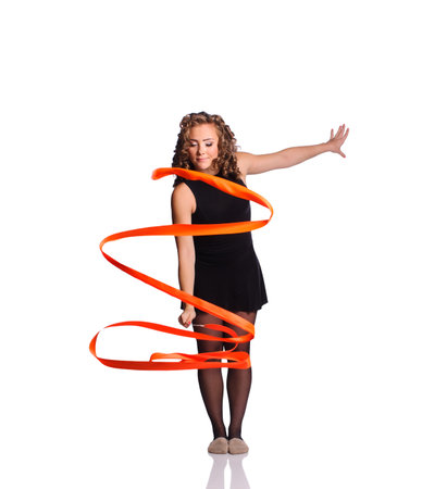 Young beautiful dancer gymnastics posing in studio with color ribbon over white backgroundの写真素材