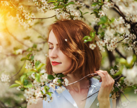 Portrait of a young woman in the blossom gardenの写真素材