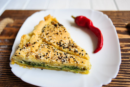 Homemade spinach french pie quiche lorraine on a white wooden boardの写真素材