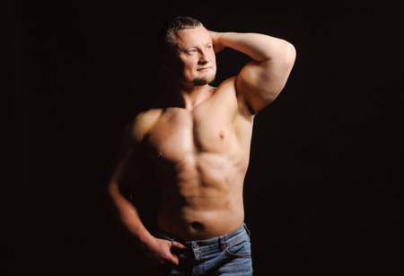 Image of muscle man posing in studio over black backgroundの写真素材