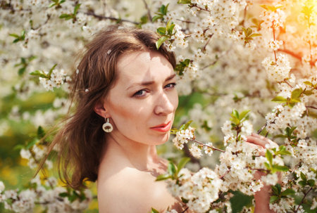 Portrait of a young woman in the blossom gardenの写真素材
