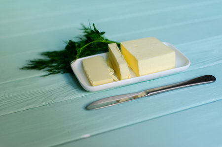 piece of butter with parsley on a lime wooden deskの写真素材