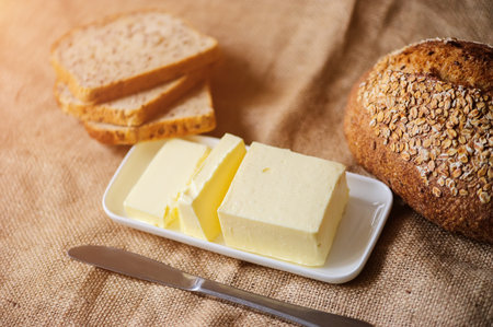 piece of butter with bread on a sacking textile materialの写真素材