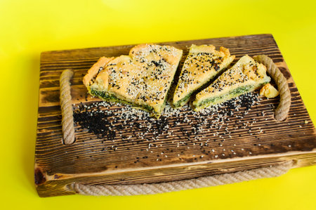 Homemade spinach french pie quiche lorraine on a wooden board over yellow backgroundの写真素材