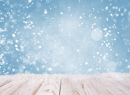 Christmas background with white wooden desk, covered by snowの写真素材