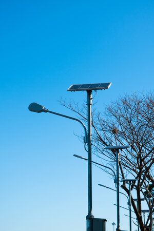 Solar lamp post on the blue sky and the tree in the backgroundの写真素材