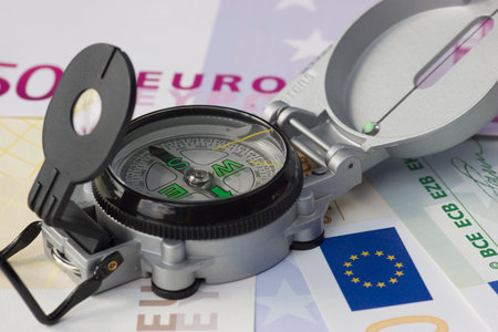 Compass lying on euro banknotesの写真素材