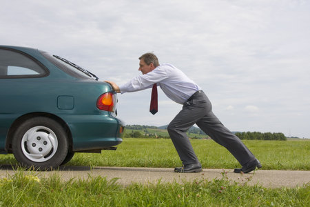 Businessman pushing a car with empty fuel tankの写真素材