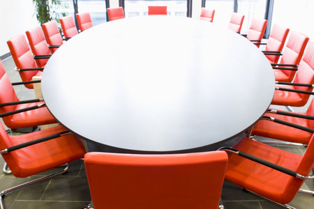 Meeting room with red chairs and oval conference table, Focus on the chair in the foregroundの写真素材