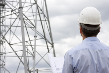 Engineer looking at construction side with plan in his hand