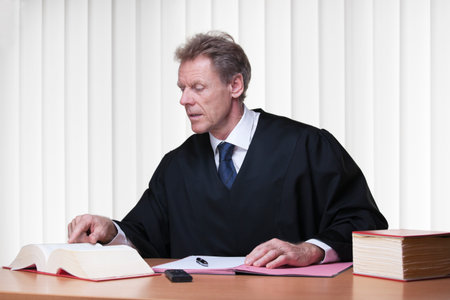 Judge or lawyer reading in a statute book in a bright courtroomの写真素材