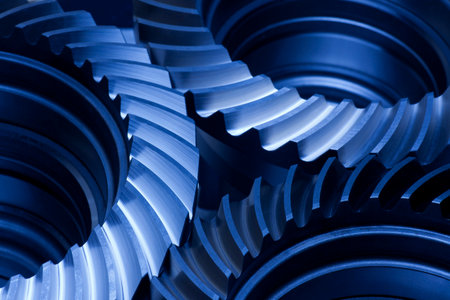 Close-up of three gear wheels in an engine in dark blueの写真素材