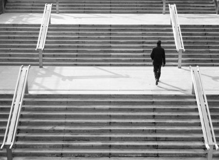 Man walking up a modern staircase in a city - monochrome pictureの写真素材