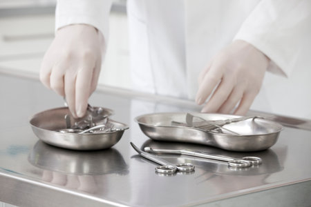 Hands of a nurse taking medical instruments - focus on the scissors in the foregroundの写真素材
