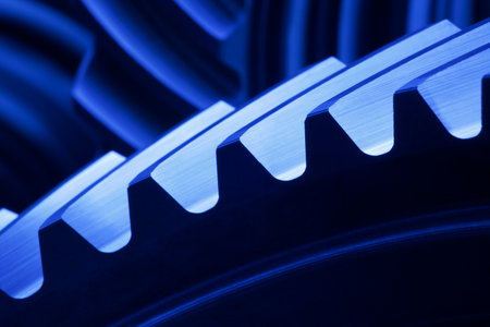 Close-up of cog wheels in a machinery in dark blue with blurred backgroundの写真素材
