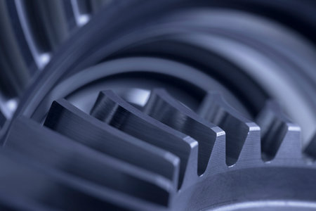 Close-up of a machinery with cog wheels with blurred gray backgroundの写真素材