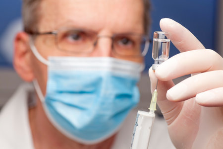 Close-up of doctor preparing a syringe for vaccination - focus on the syringeの写真素材