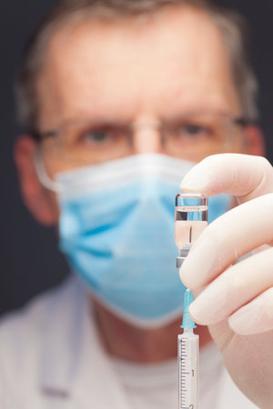 Close-up of doctor preparing a syringe for vaccination - focus on the syringeの写真素材