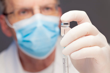 Close-up of doctor preparing a syringe for vaccination - focus on the syringeの写真素材