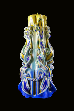 Figured freakish curled form multicolored candle wax from yellow, white and blue colors, lacquered isolated on black background with clipping maskの写真素材