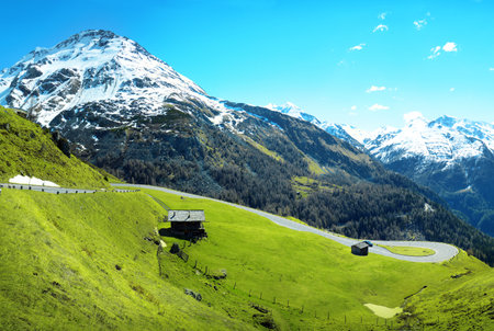Beautiful Alpen trip mountainside vista panorama of plateau. Light clouds on bright blue heaven above high crag overgrown with green groves. Rural scenic top viewの写真素材