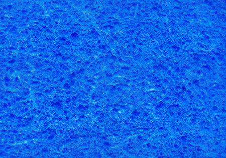 Dark scarlet color artificial synthetic cushion polyurethane scour swab wipe design for soft wet soak absorb water use or carwash scourer. Detail spongy closeup micro view and space for textの写真素材
