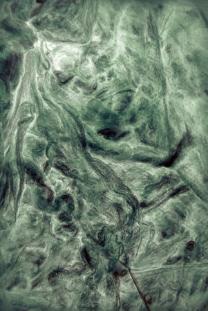 Modern artificial synthetic dark wrinkled relief. Wavy rough crumpled whirl wrapping structure. Close up top detail macro view with space for text on beige fondの写真素材