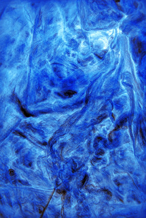 Modern artificial synthetic dark wrinkled relief. Wavy rough crumpled whirl wrapping structure. Close up top detail macro view with space for text on beige fondの写真素材